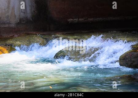 Wasserfluss zwischen Steinen, landschaftlich schöner Blick auf fließendes Wasser zwischen Steinen Stockfoto