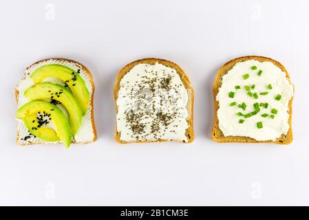 Set mit Toastbrot und verschiedenen Belägen mit Superfoods, Chiasamen, Sesamsamen auf weißem Hintergrund, Draufsicht Stockfoto