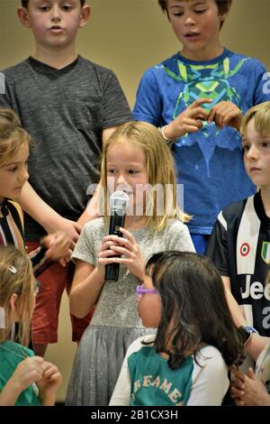 2. Klasse Schüler bei der Versammlung, im Gespräch mit Eltern und Besuchern ohne Gesichtsmaske und oder soziale Distanzierung in der Schule in Zentral-Kalifornien Stockfoto