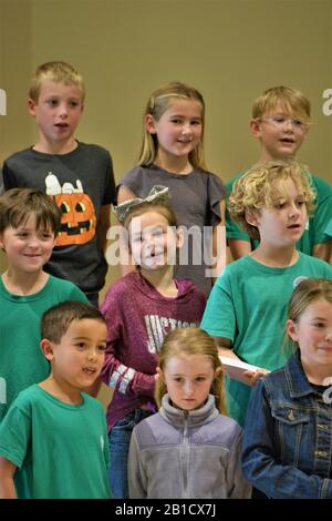 2. Klasse Schüler bei der Versammlung, im Gespräch mit Eltern und Besuchern ohne Gesichtsmaske und oder soziale Distanzierung in der Schule in Zentral-Kalifornien Stockfoto