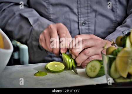 Barkeeper schneidet die Artikel an der Bar draußen, um sie zu den harten Likörgetränken hinzuzufügen Stockfoto