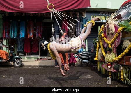 Devotee, der von Hook-Piercings als ritueller Akt der Hingabe hängt, Garudan Theokkam, während Thaipooyam (Thaipoosam) in Kedakulam, Kerala, Indien. Stockfoto