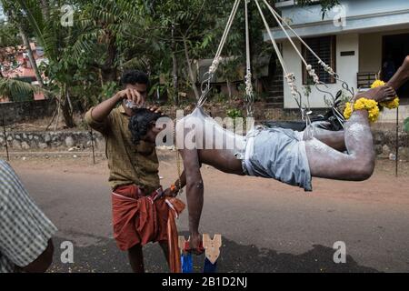 Devotee, der von Hook-Piercings als ritueller Akt der Hingabe hängt, Garudan Theokkam, während Thaipooyam (Thaipoosam) in Kedakulam, Kerala, Indien. Stockfoto