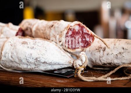 Fermentierter Fleischsalami in Gehäusen, zum Aufhängen angebrachte Schnur. Stockfoto