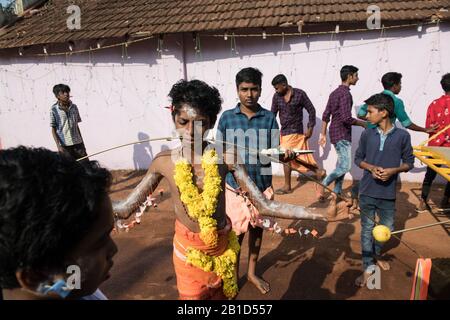 Anhänger, die Speere in ihren durchbohrten Mündern (Kavadi Aattam) als Akt der Hingabe während Thaipooyam oder Thaipoosam, Festival in Kedakulam, Kerala, halten. Stockfoto