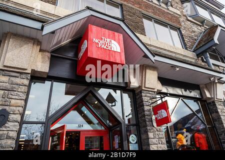 Banff, KANADA - 15. FEBRUAR 2020: Berühmter amerikanischer Freilufthändler The North Face Shop mit seinem Schild an der belebten Banff Avenue in Alberta, Kanada. Stockfoto
