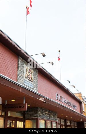 Banff, KANADA - 15. FEBRUAR 2020: Hudson's Bay Shop mit Schild an der belebten Banff Avenue in Alberta, Kanada. Hudson's Bay, auch bekannt als Bay oder HBC, ist Stockfoto