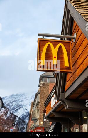Banff, KANADA - 15. FEBRUAR 2020: McDonald's Restaurant mit seinem einzigartigen kanadischen Schild aus Ahorn an der belebten Banff Avenue in Alberta, Kanada. Die berühmte Amer Stockfoto