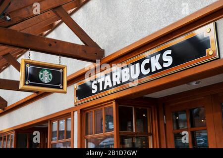 Banff, KANADA - 15. FEBRUAR 2020: Starbucks Schild an der belebten Banff Avenue in Alberta, Kanada. Stockfoto