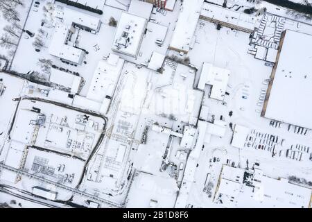 Luftbild aus der Drohne des Industriegebietes mit Lagerhäusern, Fabrikgebäuden und im Winter geparkten Autos Stockfoto