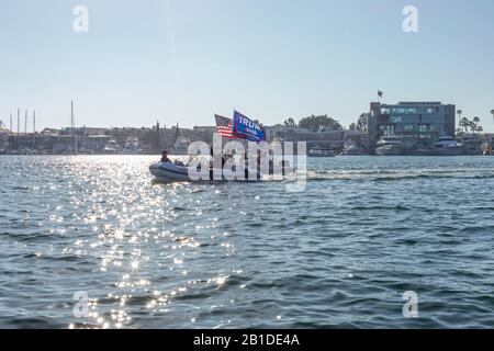 Bootsfahrer fahren in Newport Bay mit und American Flag und einer Trump-Fahne, die von ihren Booten fliegt. Newport Bay, Kalifornien, USA. Stockfoto