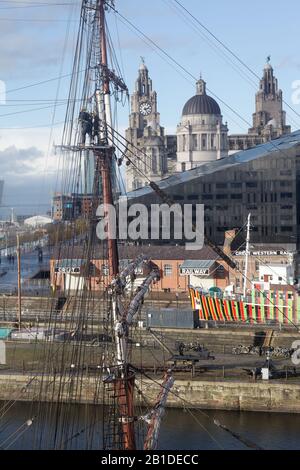 Liverpool Waterfront und die Drei Graces vom Merseyside Maritime Museum aus gesehen; das farbenfrohe Schiff ist der Lotsenschneider Edmund Gardner Stockfoto