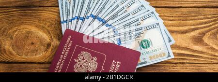 Dollar Banknoten im Ventilator und Pass an der hölzernen Hintergrund Stockfoto