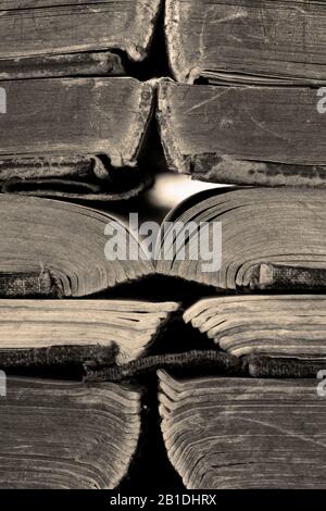 Alte, offene Bücher, die übereinander gestapelt sind. Mit Farbtonierung Stockfoto