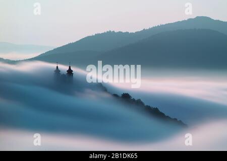 Über Wolken in Banska Stiavnica, Slowakei Kalvarienberg Stockfoto