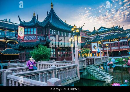 Ein Tourist, der eine Gesichtsmaske trägt, nimmt ein selfie vor dem Huxinting Teehaus im Shanghaier Yuyuan. Stockfoto