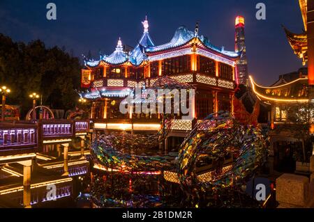 Ein Drachenschmuck aus Neujahr vor Yuyuans Huxinting Teehaus mit dem dahinter liegenden Shanghai-Turm. Verlassen wegen des Coronavirus. Stockfoto