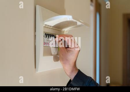 Handschalter an einem Sicherungskasten. Nahaufnahme des Schalters des Sicherungskastens durch Elektriker Stockfoto