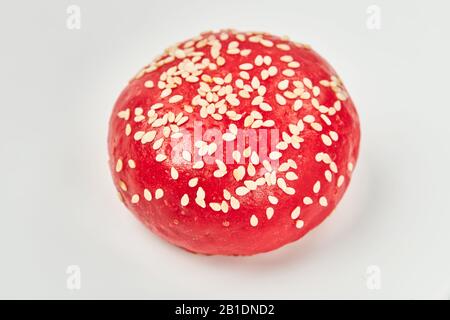 Runde schmackhafte rote Brötchen mit Sesamsamen auf weißem Grund bestreut. Stockfoto