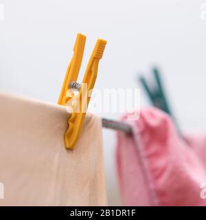 Beige und rosafarbene Bettwaren werden im Freien an einem Seil getrocknet Stockfoto