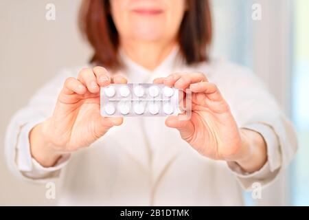 Arzt empfiehlt Pillen für den Patienten. Lächelnder Arzt hält Medikamente in den Händen. Nahansicht. Stockfoto