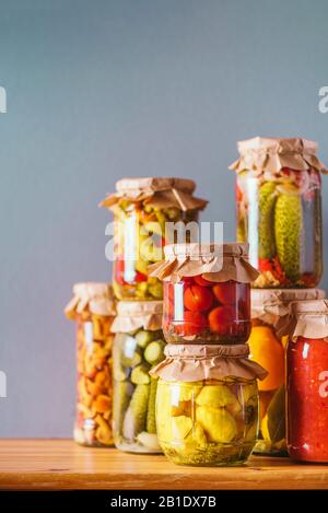 Konservierte und fermentierte Lebensmittel in Glasgefäßen. Fermentierte Lebensmittel. Herbstcanning. Сucumber, Squash und Tomaten, die in Glasgefäße gebeizt und eingescannt werden Stockfoto