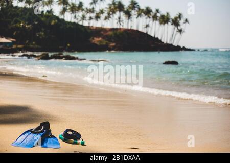 Tauchmaske mit Flossen am Strand. Blaue Flipper am Ufer. Stockfoto