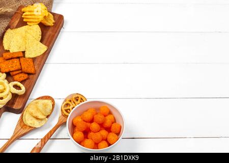 Snacks: Brezeln, Cracker, Pommes und Nachos auf dem Tisch Stockfoto