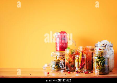 Probiotika Lebensmittel Hintergrund. Koreanische Karotte, Kimchi, Rote Bete, Sauerkraut, eingepickte Gurken in Glasgefäßen. Winterfermentiertes und Konservennahrungskonzept. Banner mit Kopierbereich. Stockfoto
