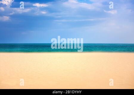 Leerer sonniger tropischer Strand und bewölkter Himmel Stockfoto
