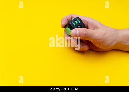 Antistress Fidget in bemannt rechte Hand auf gelbem Hintergrund Stockfoto