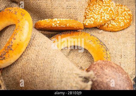 Plätzchen, Schokoladenkuchen und Bagels auf dem Hintergrund rauer Homespun-Qualität. Nahaufnahme Stockfoto