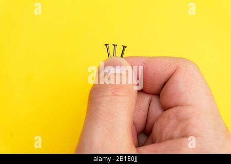 Nahaufnahme der Nägel in bemannt Finger auf gelbem Hintergrund Stockfoto