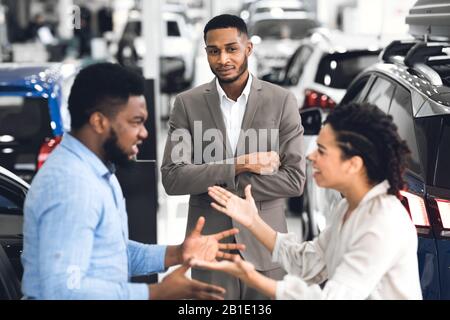 Autoverkäufer, Die Ein Paar Im Händlerschauraum Streiten Stockfoto