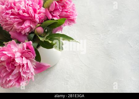 Rosafarbene Pfirsich blühen in Vase auf Grau. Kopierbereich. Draufsicht. Stockfoto