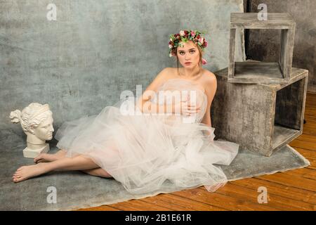 Junges weibliches Modell posiert im Studio. Wunderschönes Mädchen, das auf dem Boden liegt Stockfoto