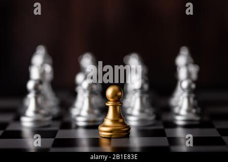 Goldchip und silbernes Schach an Bord im Spiel Stockfoto