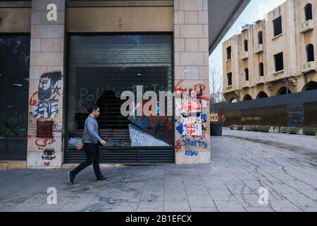 Beirut, Libanon. 25. Februar 2020: Ein Fußgänger spaziert an einer Ladenfront im zentralen Geschäftsviertel von Beirut, das von Regierungsgegnern mit Graffiti bedeckt ist, die sich gegen die Korruption der Regierung und die Sparmaßnahmen der Wirtschaft einsetzen. Demonstranten haben sich mit den libanesischen Sicherheitskräften in Beirut zusammengetan, die versuchten, ein Vertrauensvotum im parlament über das neue Kabinett zu stoppen, das ihrer Meinung nach ihren Forderungen nicht entspricht, und den Libanon nicht vor wirtschaftlichen Katastrophen retten können.Credit: Amer Ghazzal/Alamy Live News Stockfoto