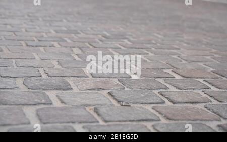 Hintergrundbild der Straße aus Stein aus Granit. Leichter Bürgersteig, Straßenbelag Stockfoto