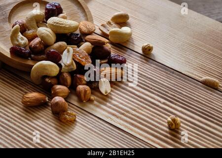 Mischung aus Nüssen und getrockneten Früchten auf verwittertem Holzhintergrund. Stockfoto