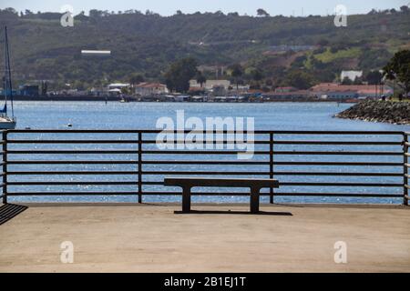 Leere Zementbank am Angelpier mit Blick auf die Segelboote in San Diego Bay Stockfoto