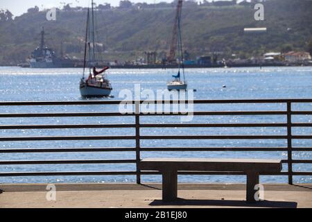 Leere Zementbank am Angelpier mit Blick auf die Segelboote in San Diego Bay Stockfoto