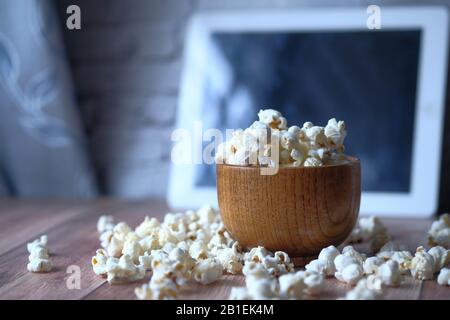 Nahaufnahme von Popcorn in einer Schüssel und digitaler Tablette auf dem Tisch Stockfoto