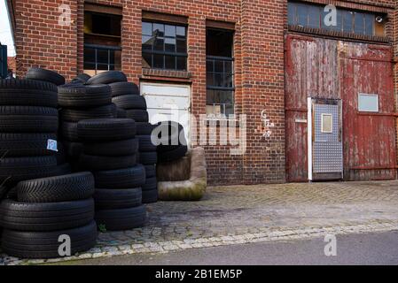 Alte Autoreifen vor einer alten Garage, Industriecharme, alte Wagenhalle mit alten Reifen vorne, Garage, Autowerkstatt Stockfoto
