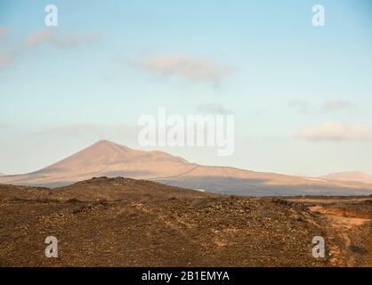 Blick auf den alten Vulkan von der kargen Landschaft der Kanarischen Inseln Lanzarote Spanien. Stockfoto