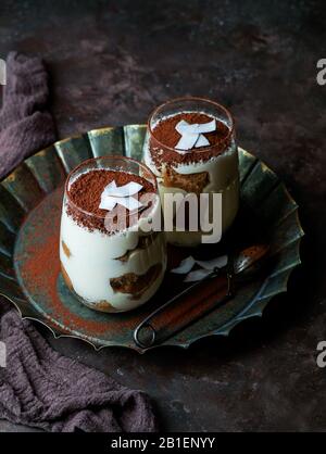 Tiramisu-Dessert in Gläsern auf dunklem Betonhintergrund Stockfoto