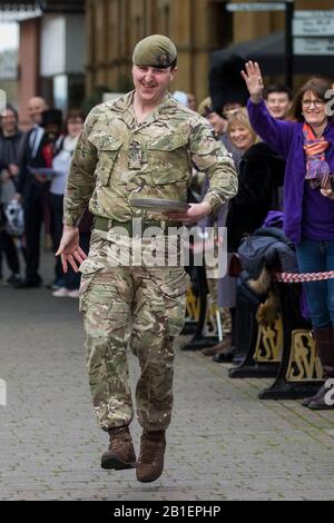 Windsor, Großbritannien. Februar 2020. Ein Soldat der 1st Battalion Welsh Guards zieht einen Muskel, als er am Dienstag in Shrove in der Windsor and Eton Flippin' Pancake Challenge um Hilfe des Alexander Devine Children's Hospice Service konkurriert. Credit: Mark Kerrison/Alamy Live News Stockfoto