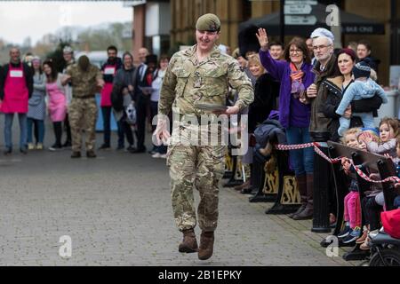 Windsor, Großbritannien. Februar 2020. Ein Soldat der 1st Battalion Welsh Guards zieht einen Muskel, als er am Dienstag in Shrove in der Windsor and Eton Flippin' Pancake Challenge um Hilfe des Alexander Devine Children's Hospice Service konkurriert. Credit: Mark Kerrison/Alamy Live News Stockfoto