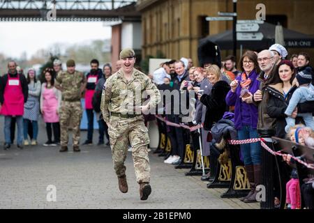 Windsor, Großbritannien. Februar 2020. Ein Soldat der 1st Battalion Welsh Guards zieht einen Muskel, als er am Dienstag in Shrove in der Windsor and Eton Flippin' Pancake Challenge um Hilfe des Alexander Devine Children's Hospice Service konkurriert. Credit: Mark Kerrison/Alamy Live News Stockfoto