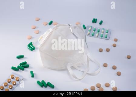 Zwei antibakterielle Schutzmasken N95 und ein Haufen therapeutischer medizinischer Medikamente Stockfoto